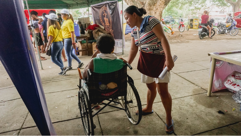 Maricel checks on her father as he sits right outside the complex for fresh air.