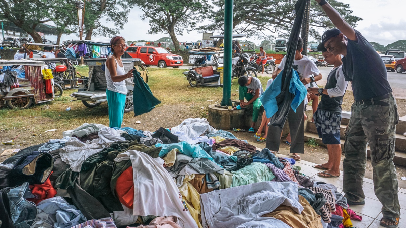 Evacuees rummage through a mountain of clothing donations.